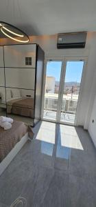 une chambre avec un lit et une grande fenêtre dans l'établissement Infinity sea view, à Lávrio