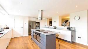 a large kitchen with white cabinets and a counter top at The Telephone Exchange at Parsley Hay in Buxton