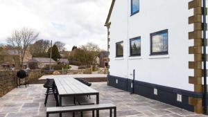 a picnic table and benches next to a building at The Telephone Exchange at Parsley Hay in Buxton