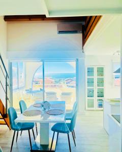 una sala da pranzo con tavolo e sedie e un balcone di La Sirène - Loft moderne et lumineux avec vue panoramique sur Mer Méditerranée et port de plaisance a Frontignan Altre 17 foto