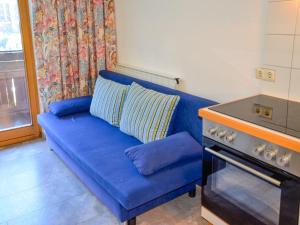 a blue couch in a kitchen next to a stove at Apartment Kassler - KPL602 by Interhome in Kappl