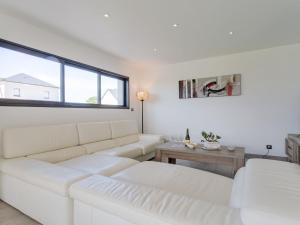 ein weißes Wohnzimmer mit einer Couch und einem Tisch in der Unterkunft Holiday Home Pirou Beach by Interhome in Pirou