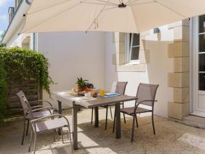 a table and chairs with an umbrella on a patio at Holiday Home La Marinière Izella - SNR101 by Interhome in Sainte-Marine