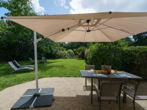 a table with an umbrella in a garden at Holiday Home La Marinière Izella - SNR101 by Interhome in Sainte-Marine