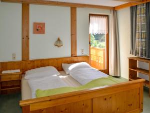 1 dormitorio con cama grande de madera y ventana en Apartment Simon-1 by Interhome, en Kappl