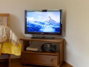 einen Flachbild-TV auf einem Holzständer in der Unterkunft Apartment Alba by Interhome in Zermatt
