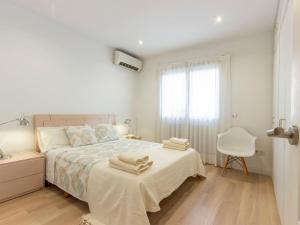 a white bedroom with a bed with towels on it at Apartment Chamartin-Ciudad Ramos Carrion by Interhome in Madrid