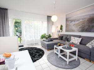 uma sala de estar com um sofá e uma mesa em Apartment Muschelweg-2 by Interhome em Norddeich