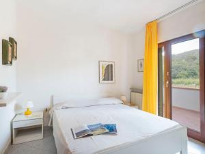 a white bedroom with a bed and a window at Apartment Turistica-1 by Interhome in Capoliveri