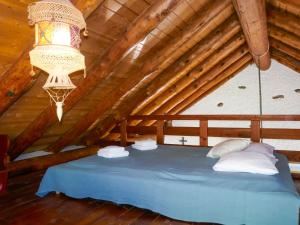 a blue bed in a attic with a chandelier at Holiday Home Rustico Girasole by Interhome in Leontica