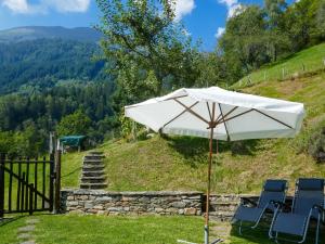 a table and chairs under an umbrella on a hill at Holiday Home Rustico Girasole by Interhome in Leontica