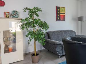 a living room with a chair and a plant at Holiday Home Achterblick 2 by Interhome in Altefähr