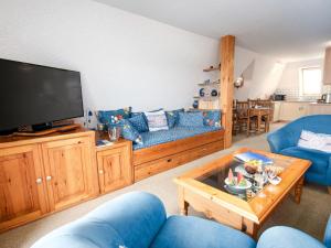 sala de estar con muebles azules y TV de pantalla plana en Apartment Dehne-5 by Interhome, en Norddeich