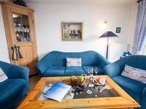 ノルトダイヒにあるApartment Dehne-5 by Interhomeのリビングルーム(青いソファ2台、コーヒーテーブル付)