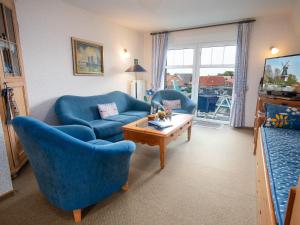 sala de estar con 2 sillas azules y mesa en Apartment Dehne-5 by Interhome, en Norddeich