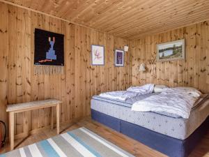 ein Schlafzimmer mit einem Bett in einer Holzwand in der Unterkunft Chalet Ängsjömåla by Interhome in Eringsboda