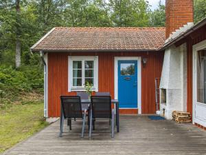 Eringsboda的住宿－Chalet Ängsjömåla by Interhome，门廊上的一张桌子和椅子,门廊上设有蓝色的门