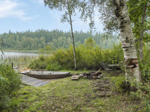 a boat on a dock next to a lake at Chalet Ängsjömåla by Interhome in Eringsboda