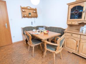 a kitchen with a wooden table and chairs at Apartment Tunnelstrasse-1 by Interhome in Norddeich