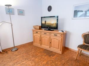 a tv sitting on top of a wooden cabinet at Apartment Tunnelstrasse-1 by Interhome in Norddeich