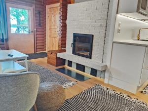 salon z kominkiem z białej cegły w obiekcie Holiday Home Koivula by Interhome w mieście Soini