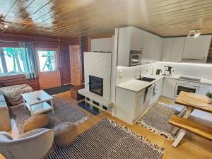 ein Zimmer mit einer Küche und einem Wohnzimmer mit einem Kamin in der Unterkunft Holiday Home Koivula by Interhome in Soini