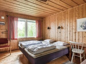 Undersåker的住宿－Chalet Högvallen Elden - JAM025 by Interhome，木制客房内的一间卧室,配有一张床