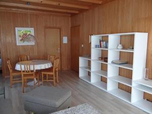 ein Wohnzimmer mit einem Tisch und einem Bücherregal in der Unterkunft Apartment Valentine by Interhome in Engelberg