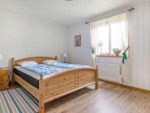 a bedroom with a wooden bed and a window at Holiday Home Gaslunda - B in Olofström