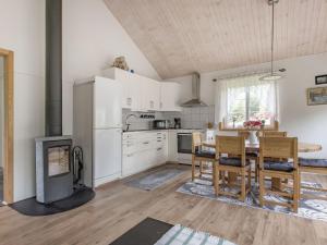 eine Küche mit einem Tisch und Stühlen sowie einem Kamin in der Unterkunft Holiday Home Gaslunda by Interhome in Olofström