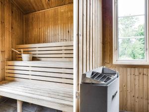 a sauna with a trash can next to a window at Holiday Home Klinten Totebo - SND150 by Interhome in Totebo