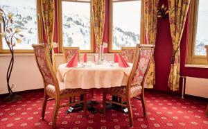 a dining room with a table and two chairs at Heart Hotel Aurora in Obertauern