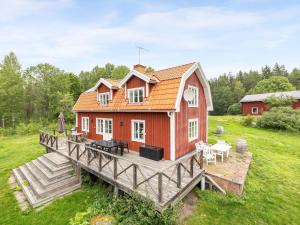 una casa roja en un puente con terraza en Holiday Home Klinten Totebo - SND150 by Interhome, en Totebo