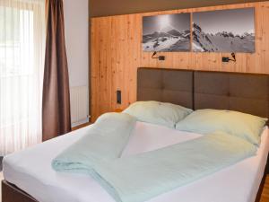 ein Bett mit weißer Bettwäsche und Kissen in einem Schlafzimmer in der Unterkunft Apartment Kathrein - ISL507 by Interhome in Ischgl