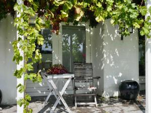 une chaise assise sous une pergola devant une maison dans l'établissement Chalet De Orangerie by Interhome, à Zaamslag