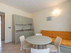 eine Küche mit einem Tisch, Stühlen und einem Sofa in der Unterkunft Apartment Borgoverde-1 by Interhome in Imperia