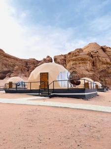 a group of domes in a desert with rocks at Daniela Camp Wadi Rum in Wadi Rum