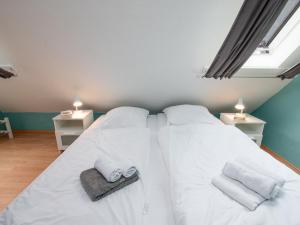 ノルトダイヒにあるApartment Leuchtfeuer by Interhomeのベッドルーム1室(ベッド2台、白いシーツ、タオル付)