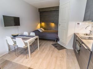 ein kleines Apartment mit einem Tisch, Stühlen und einem Bett in der Unterkunft Holiday Home Vuosselinhelmi c6 by Interhome in Ruka