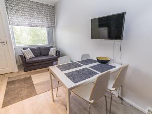 einen Esstisch mit Stühlen und einen TV an der Wand in der Unterkunft Holiday Home Vuosselinhelmi c6 by Interhome in Ruka
