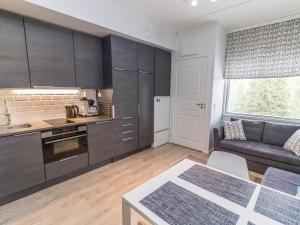 eine Küche und ein Wohnzimmer mit einem Sofa und einem Tisch in der Unterkunft Holiday Home Vuosselinhelmi c6 by Interhome in Ruka