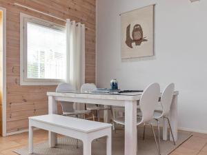 ein weißes Esszimmer mit einem weißen Tisch und Stühlen in der Unterkunft Holiday Home Karitahko a 3 by Interhome in Tahkovuori