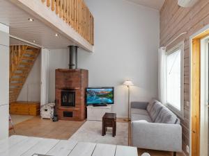 ein Wohnzimmer mit Sofa und Fernseher in der Unterkunft Holiday Home Karitahko a 3 by Interhome in Tahkovuori