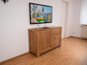 a television on top of a wooden dresser in a room at Apartment Dehne-3 by Interhome in Norddeich +28 photos