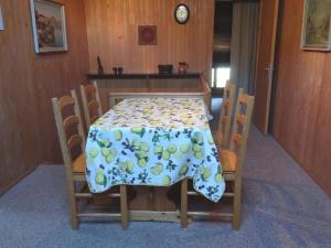 einen Tisch und Stühle mit einer Tischdecke mit Trauben drauf in der Unterkunft Apartment Valentine by Interhome in Engelberg