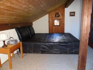Ce lit se trouve dans un dortoir doté d'un plafond en bois. dans l'établissement Apartment Valentine by Interhome, à Engelberg