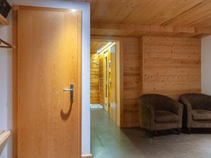 - une chambre avec deux chaises et une porte en bois dans l'établissement Chalet Mimique by Interhome, à Nendaz