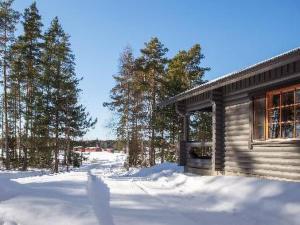 uma cabana de madeira na neve ao lado de algumas árvores em Holiday Home Marttalanmäki by Interhome em Valittula