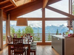 een eetkamer met een tafel en stoelen en een groot raam bij Chalet Mimique by Interhome in Nendaz +55 foto's