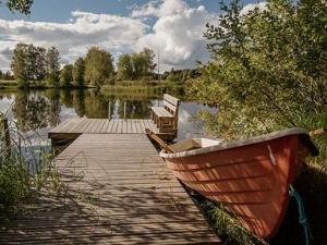 um barco sentado ao lado de uma doca num lago em Holiday Home Marttalanmäki by Interhome em Valittula